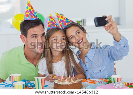 Woman taking pictures of her family during her daughter birthday party