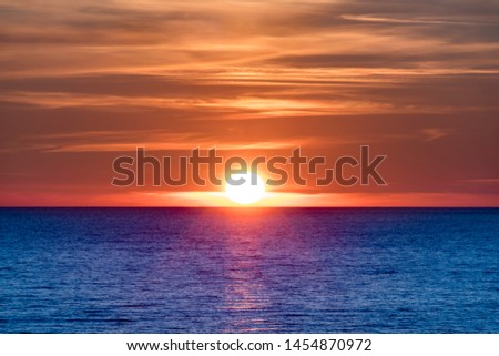 Beautiful Setting sun at beach Tylosand Halmstad, one of Swedens most popular beaches. Orange Sun set over blue ocean.
