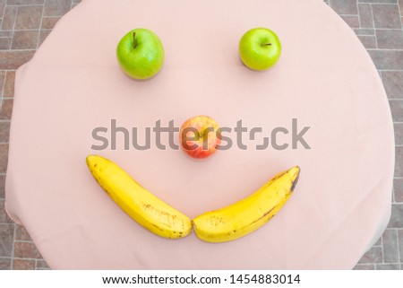 Happy face formed with fruits. Apples and banana forming a face. Happiness.