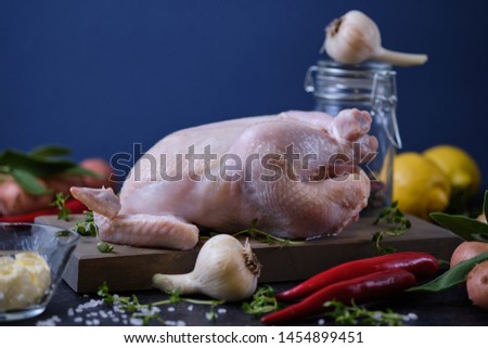 The process of cooking chicken with herbs, spices and lemon in the oven. On the table are the products that are needed for cooking.