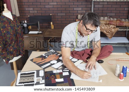 Mature male fashion designer working on sketch in design studio