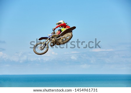 Biker does the trick and jumps in the air. Extreme concept, adrenaline. Copy space. Sky background