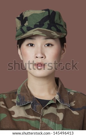 Portrait of beautiful young US Marine Corps soldier in camouflage clothing over brown background