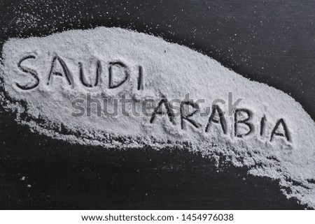 the word "Saudi Arabia" is written in salt on a black board