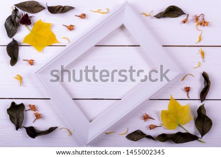 Autumn concept. Flat lay, top view. Frame made of dried flower, dried leaves on white wooden background. copy space for text.