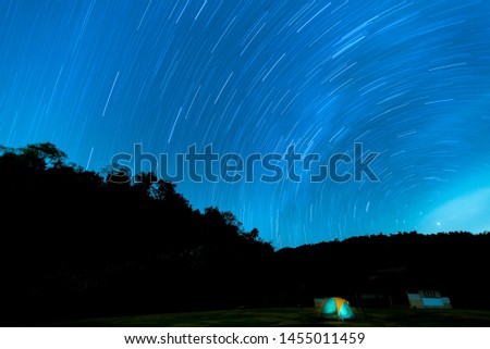 Beautiful spiral startrail at night. Fantastic star timelapse with mountain background.
Orange illuminated tent. Under sky full of star.