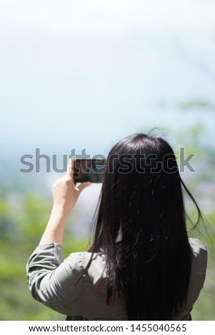 Long hair girl is shooting video of beautiful nature view on cell telephone. Female tourist is taking photo with mobile phone camera Woman taking photo.