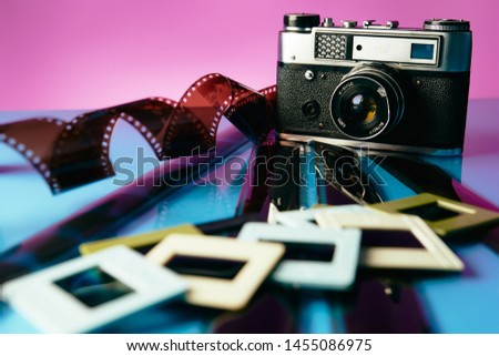 old camera and old used film on blue and violet background. mirror background