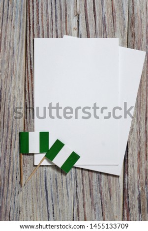 October 1, happy independence Day of Nigeria. the concept of patriotism , freedom and independence. Mini flags with a white card on wooden background