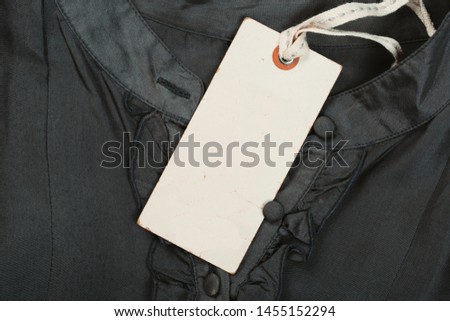 Rectangular Tag on a clothes. fashion, people and shopping concept - close up price tag of clothing item
