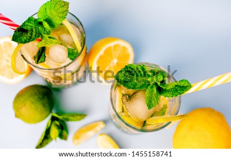 

two glasses of lemonade with lime, lemon and mint leaves