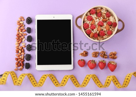 Tablet computer, porridge and measuring tape on color background. Weight loss concept