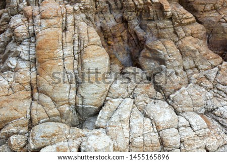 The view from the top of the close-up image of granite in the coastal area with complex patterns and rich colors with original colors and natural light.