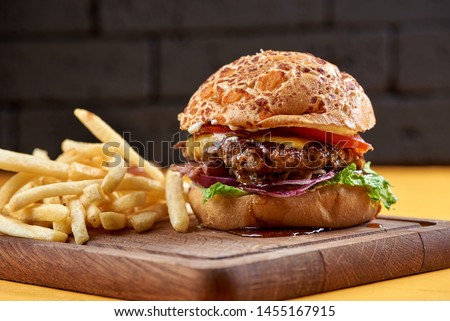 burger with onion rings, cheese and jack daniel's sauce