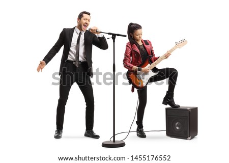Full length portrait of a male singer singing and a young woman playing an electric guitar isolated on white background