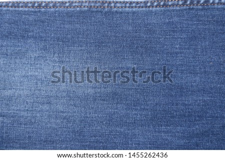 Blue background, denim jeans background. Jeans texture with seam


