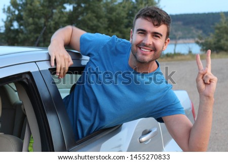 Car passenger showing peace sign during road trip