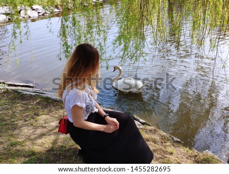 Girl on the lake and a swan. Beautiful girl.