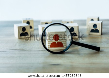 selective focus of magnifying glass near cubes on wooden desk 
