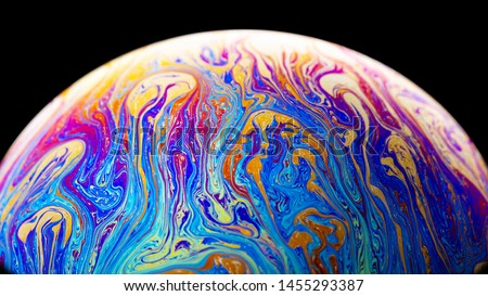 Virtual reality space with abstract multicolor psychedelic planet. Closeup Soap bubble  like an alien planet on black background Royalty-Free Stock Photo #1455293387