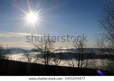 Winter sun in backlight, with fog in the valley, in Bohemian-Moravian Highlands.