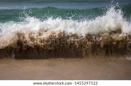 Detailed high speed photo of a wave crashing on the shore