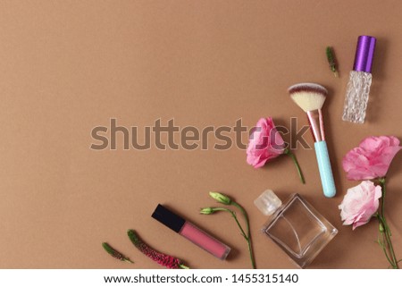 Beautiful composition of flowers and perfumes on a colored background top view
