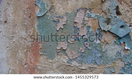old paint on a concrete wall that has cracked cubes and falls off