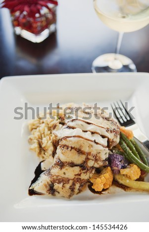 grilled halibut with beurre blanc and balsamic glaze and a glass of chardonnay
