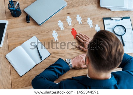 top view of man near paper human shapes on table 