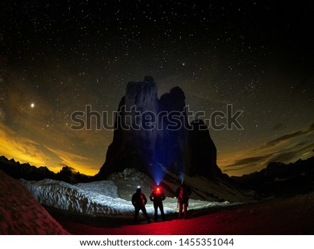 spectacular view of the Tre Cime di Lavaredo, Dolomites mountains , Italy - night view with starry sky - hikers silhouettes