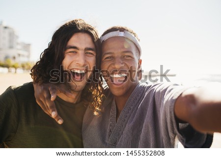 Two mixed race male friends taking selfie outside on a summer day. Cheerful friends making a selfie outdoors.
