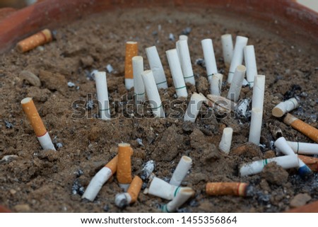 Cigarette filter in brown ceramic ashtray, concept picture, health case