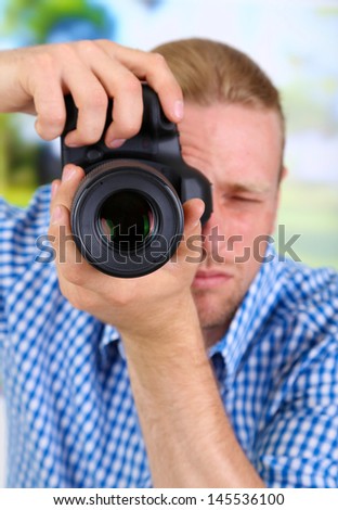 Handsome photographer with camera,on bright background