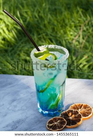 Blue cocktail with ice cubes and slices of lemon and lime. Blue lagoon summer coctail. Iced blue lemonade