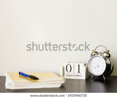 September 1 on a wooden calendar next to the alarm clock,the concept of the beginning of the school year