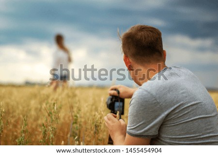 man taking photos of his girlfriend outdoor. couple leisure and pastime