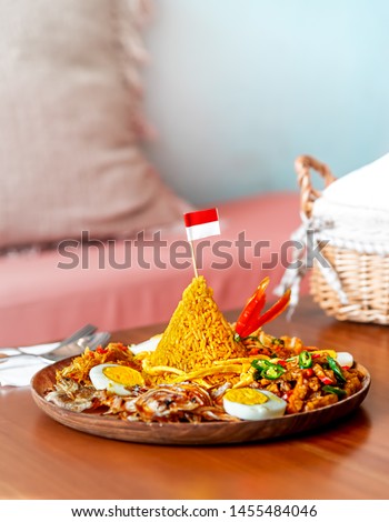 Cone Shaped Yellow Padang Rice Called Nasi Tumpeng with Indonesian National Flag on Top of For Independence Day Celebration at 17 August Royalty-Free Stock Photo #1455484046