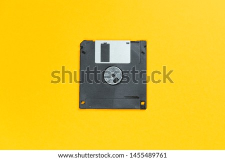 black floppy disk on orange background. retro magnetic storage