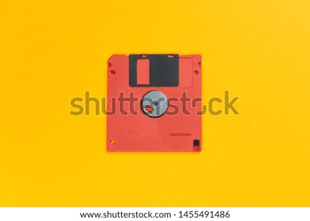red floppy disk on orange background. retro magnetic storage