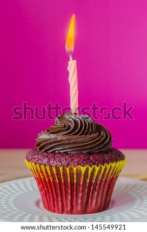 Cupcake with candle on color background