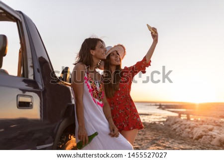 cute friends enjoying a sunset on the beach having a good time smiling