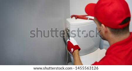 plumber working in toilet installing water pipe to wc tank copy space