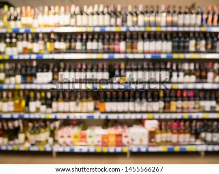 Supermarket shelf with alcoholic beverages store blured background with bokeh. Defocused image