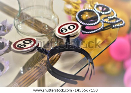 On the table of the party Arches of hair with number 60 and glasses with brightness