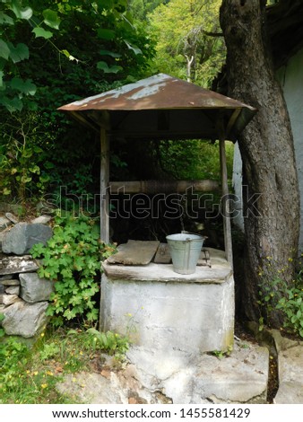 A picture of an old well that is in a very old village