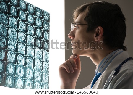 male doctor looking at the x-ray image attached to the glowing screen