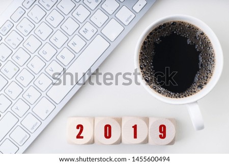 cubes in front of a keyboard and coffee showing 2019 on top