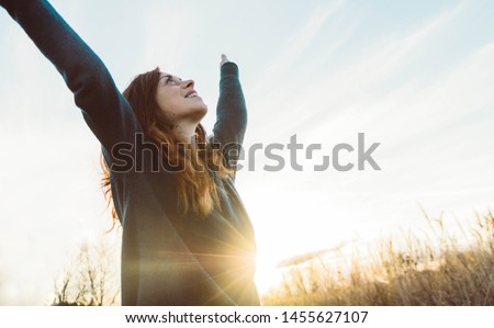 Woman happy smiling joyful with arms up in a wheat field. Happiness bliss freedom concept. Royalty-Free Stock Photo #1455627107