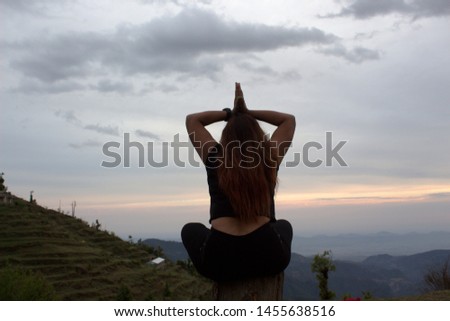 A girl is sitting in a yoga posture on mountain